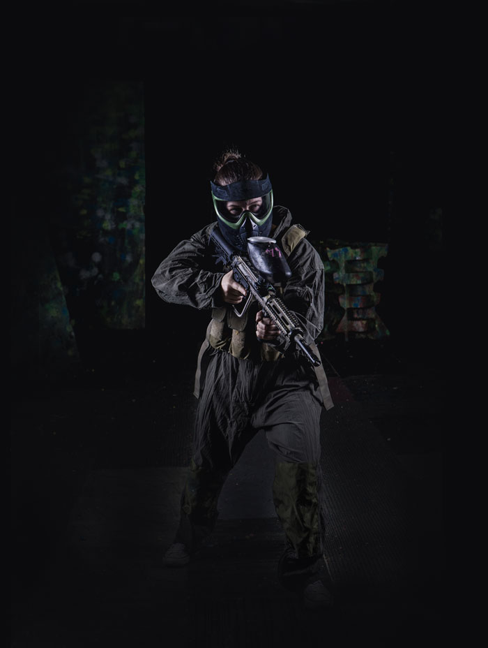 female paintball player in full flight suit and gear